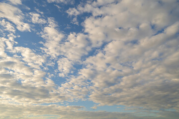 Clear blue sky with white fluffy clouds at noon. Day time. Abstract nature landscape background.