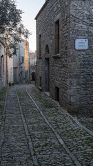 Alley in Erice, Sicily, Italy. Paved street and houses.