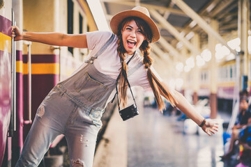 Fototapeta premium Asian young girl taking photo, happy traveler by the train