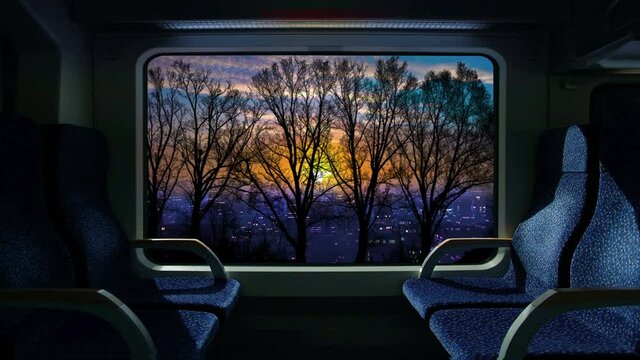 Train compartment window. 4K. Loop. Sunrise or sunset on a train journey.