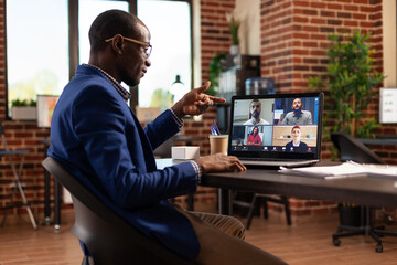 Entrepreneur attending business meeting on video call with colleagues to work on project. Employee...