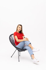 Young pretty woman sitting in armchair on white background