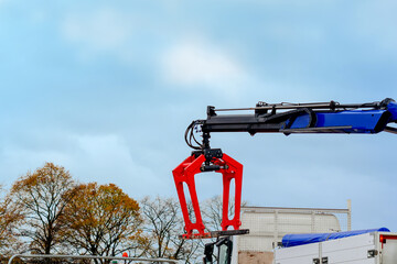 Construction materials delivered on site and being offloaded by hydraulic truck mounted crane