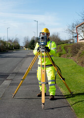 Site engineer installing robotic total station on top of wooden tripod above control point to perform surveying and setting out