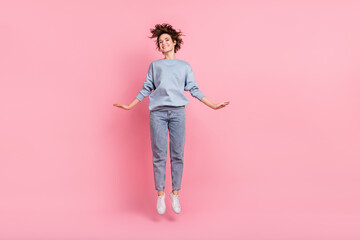 Full length photo of hooray young lady jump wear jumper jeans footwear isolated on pink background