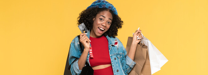 Young black woman posing with credit card and shopping bags
