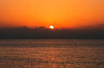 The sun's disk rises over the cloud. Morning landscape view of the sea horizon.  The Mediterranean Sea near Mersin, Turkey. Travel and tourism concept