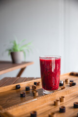 Summer red drink coctail in glass jar, with fresh berries on wooden board game