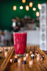 Summer red drink coctail in glass jar, with fresh berries on wooden board game