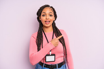 black afro woman looking excited and surprised pointing to the side. acreditation vip card