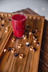 Summer red drink coctail in glass jar, with fresh berries on wooden board game