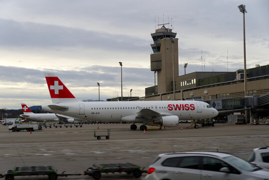 Parked Swiss airplane at Terminal A at Zürich Airport on a cloudy winter day. Photo taken January 8th, 2022, Zurich, Switzerland.