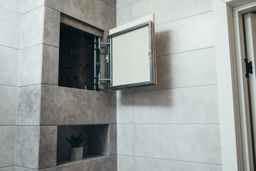 Hidden revision sanitary hatch on the wall of bathroom.