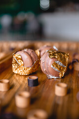 Sweet colorful French macaroon cookies dessert on brown wooden board game. Theme of rest at home during quarantine