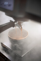 The coffee machine pours coffee in the cup, vertical view. Great picture for baner or menu