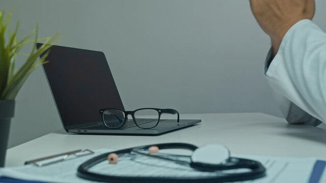 Overworked male doctor on call taking off eyeglasses to relax during break.esk with office accessories and Take a Break message. Stress management, Overload and burnout concept