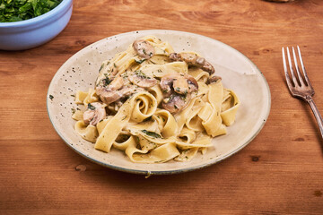 Portion of fettuccine pasta with creamy mushroom sauce on a plate - classic Italian pasta