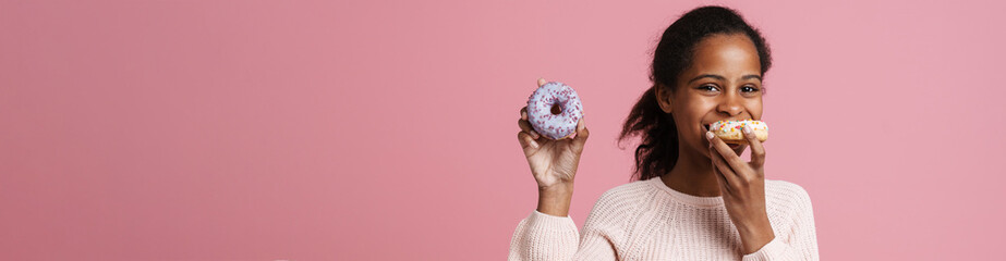 Brunette black girl laughing while eating donut