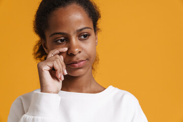 Brunette black girl wiping her tears while crying