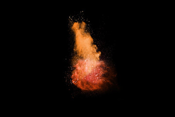Closeup of orange dust particle splash isolated on black   background. Powder explosion.