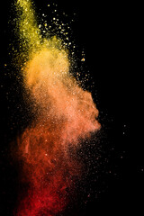 Fototapeta na wymiar Closeup of orange dust particle splash isolated on black background. Powder explosion.
