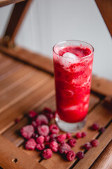 Summer red drink coctail in glass jar, with fresh berries on wooden table