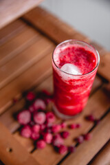 Summer red drink coctail in glass jar, with fresh berries on wooden table