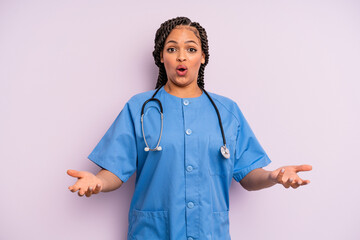 black afro woman amazed, shocked and astonished with an unbelievable surprise. nurse concept