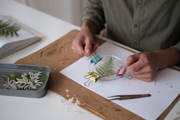 woman fixes glass plates. A picture of dried flowers. Master class on creating frame. be more creatively engaged. A Life of Happiness and Fulfillment