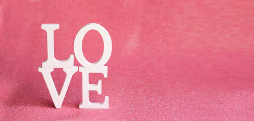 The word LOVE made of white letters on a light pink background with bokeh, Valentine's Day, lovers'...
