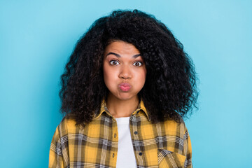 Photo of funny cute lady inflate cheeks lips send air kiss wear plaid shirt isolated blue color...