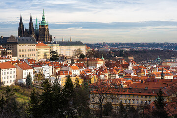 Fototapeta premium Prague city view with historical buildings. Scenic aerial view of the Old Town architecture. Picturesque landscape with old houses with red tiled roofs.