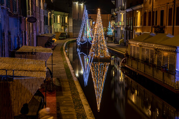 Christmas trees with lights on the canal, Comacchio, Italy