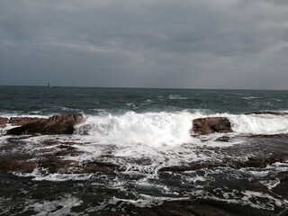 흐린날 거센 파도가 바위에 부딧치는 바닷가 풍경 / The view of the beach where strong waves hit the rocks on a cloudy day