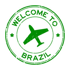 Grunge green welcome to Brazil word with airplane icon round rubber seal stamp on white background