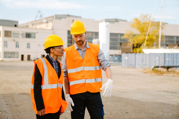 Multiracial man and woman talking while working at port