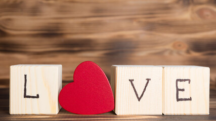 Word Love from wooden cubes and wooden red heart