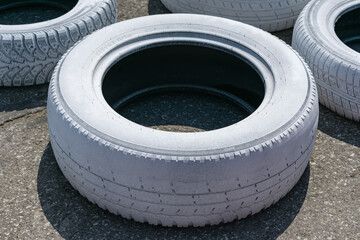 Worn used car tire, painted white and prepared for recycling