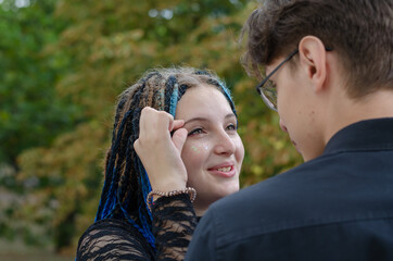 Fototapeta premium Young family. A cheerful woman pinches her eyebrow. A young man