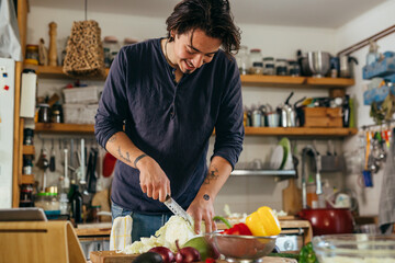 man preparing vegetable salad at home