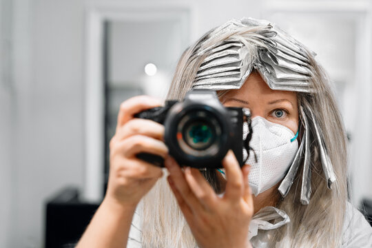 Woman with mask taking pictures at hair salon