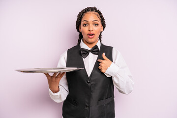 afro black woman looking shocked and surprised with mouth wide open, pointing to self. waiter with...