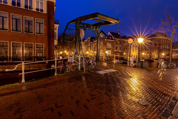 Fototapeta na wymiar Beautiful old houses on the city embankment of Leiden at sunset.