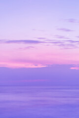 Beautiful long exposure seascape of smooth wavy sea and clound. Pink horizon with first sunset sky. verical photo.