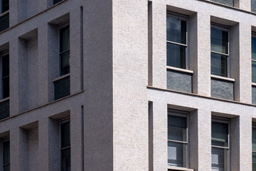 Dettaglio della facciata di un palazzo in mattoncini con tante finestre