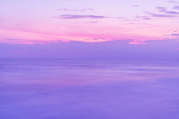 Obraz premium Beautiful long exposure seascape of smooth wavy sea and clound. Pink horizon with first sunset sky.
