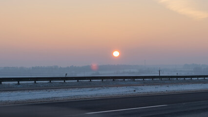 Winter landscape in snow nature with sun, field and trees. Magical winter sunset in a snow field.