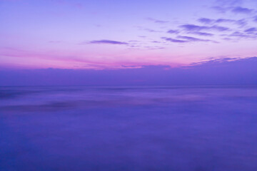 Fototapeta premium Beautiful long exposure seascape of smooth wavy sea and clound. Pink horizon with first sunset sky.