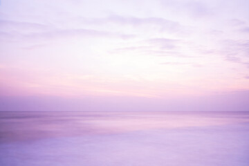 Beautiful long exposure seascape of smooth wavy sea and cloud. Pink horizon with first sunset sky.