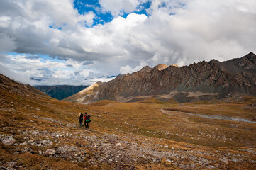 Fototapeta na wymiar Trekking group of hikers in Karakol valley on trail to Ala Kul lake. Karakol valley, Issyk-kul region, Ala-kul lake Terskey Alatau mountain range, Kyrgyzstan, Central Asia.